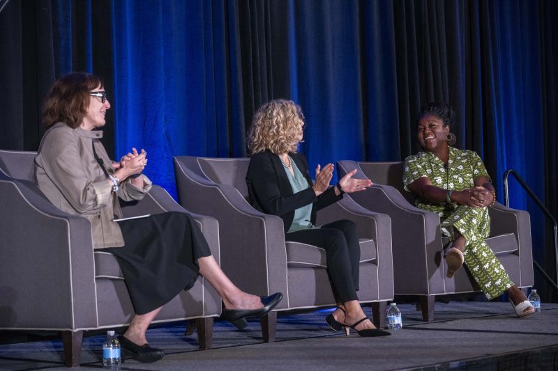 three women seated on chairs and talking