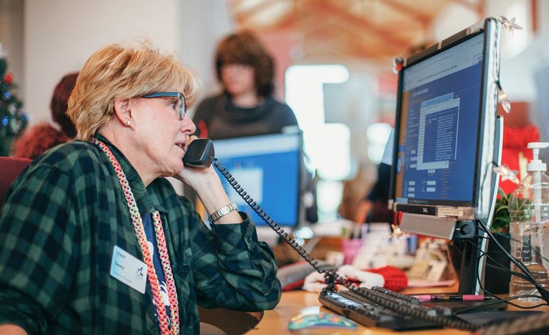 a woman at a desk talking on the phone