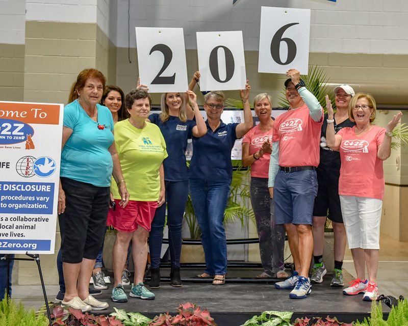 A happy group of people hold up a 206 sign