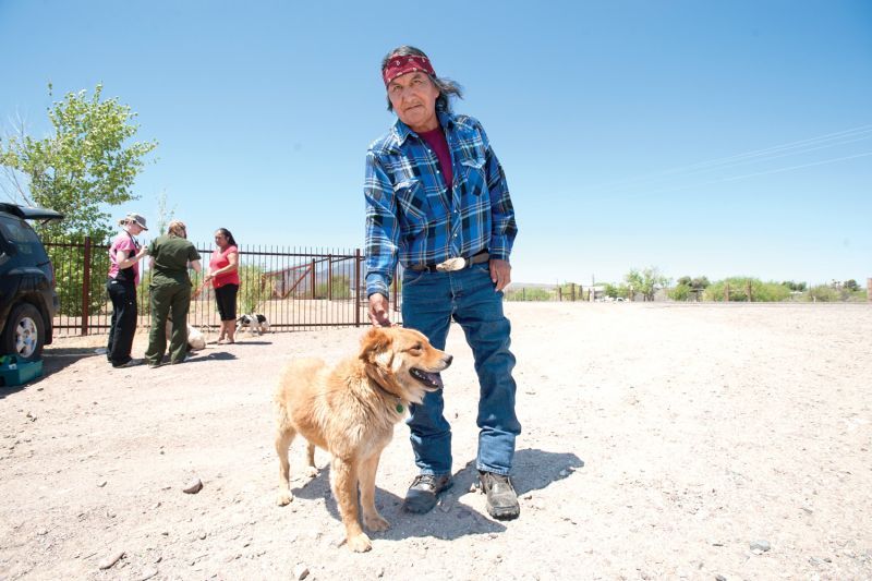 a man holds his dog by the collar