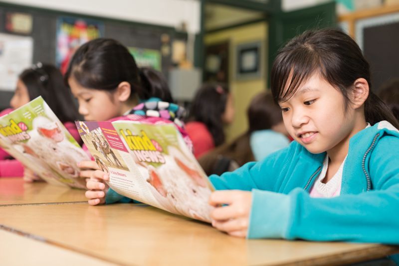 kids reading Kind News magazine