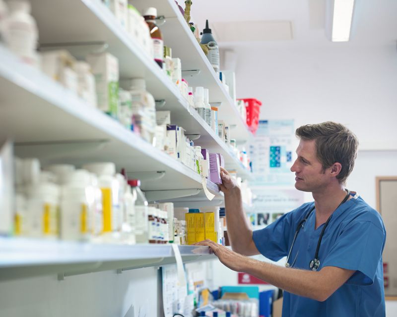a doctor looks at shelves of medication