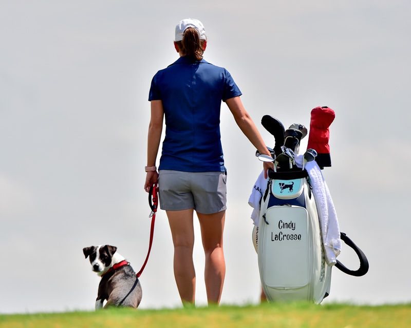 Cindy with her dog and golf bag