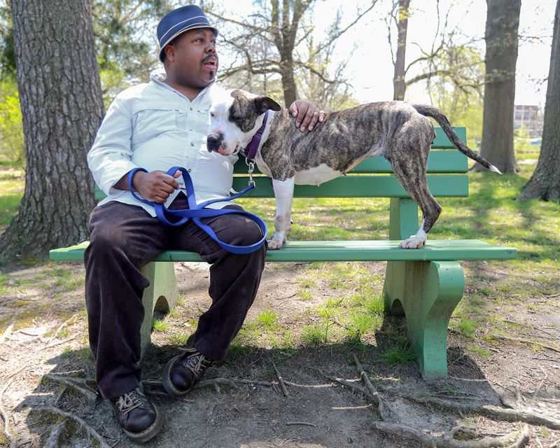 A man sitting on a bench with a dog