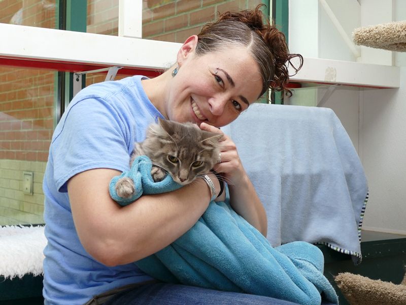 a woman cuddles a cat