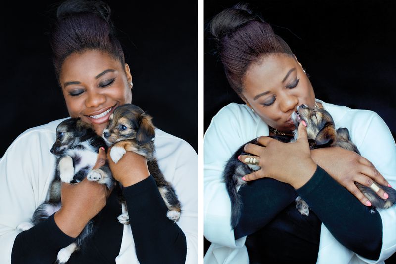 a woman snuggles two small puppies