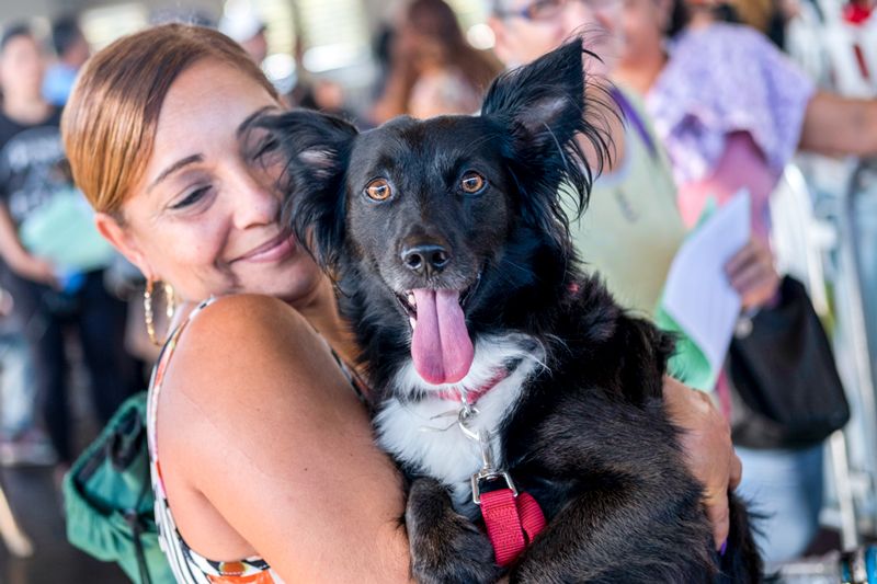 a woman holds up her dog