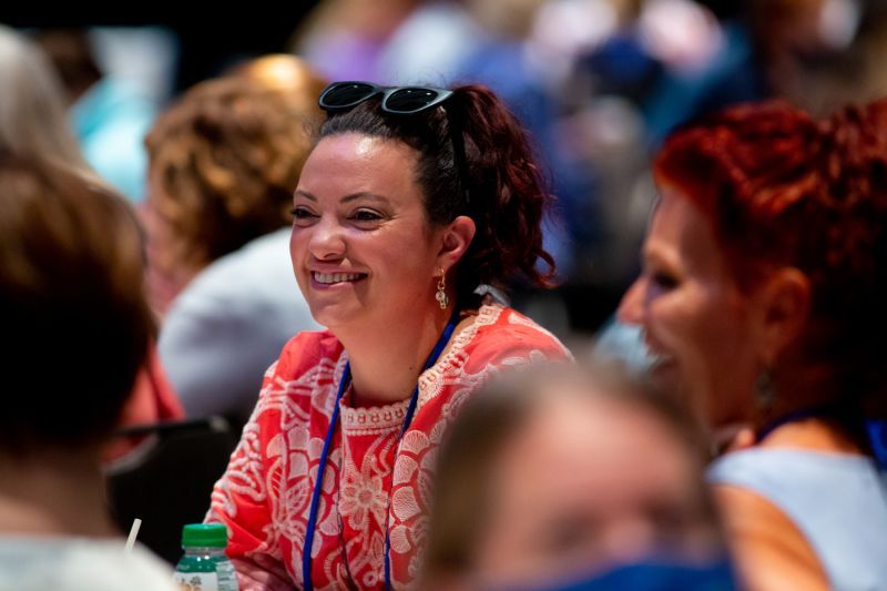 a woman smiling amidst a crowd