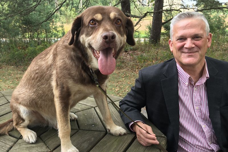 a man reclines on a table next to a dog