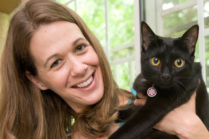 a woman holding up a cat