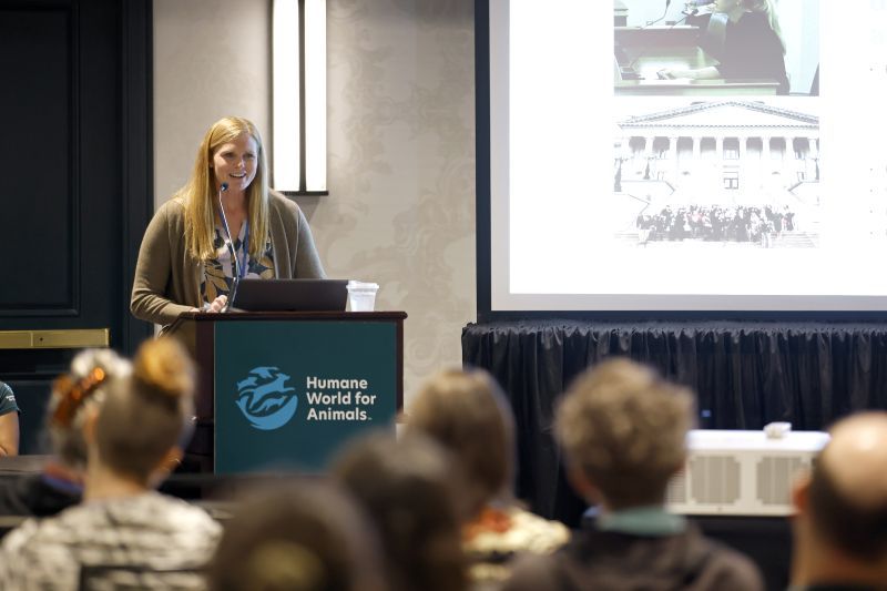A speaker stands at the podium at Taking Action for Animals 2025