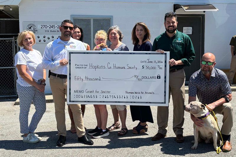 a group of people gathered behind a large ceremonial check