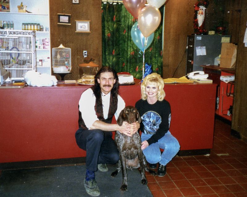 a couple stands next to their recently spayed dog
