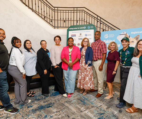 a diverse group of people posing in front of a staircase
