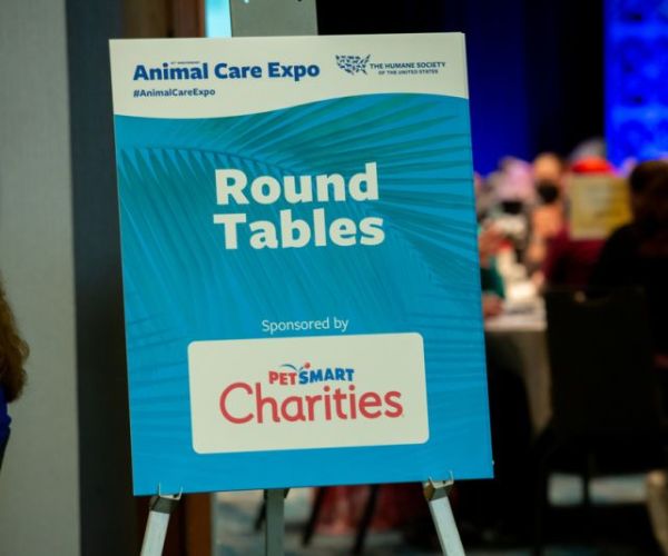 a sign for the round tables event displaying a sponsor logo