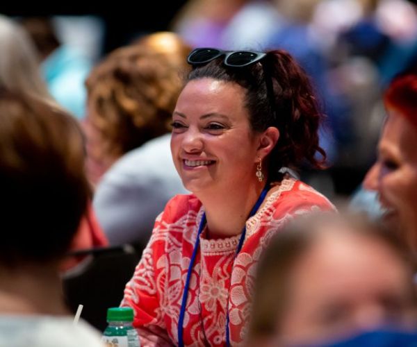 a woman smiling amidst a crowd