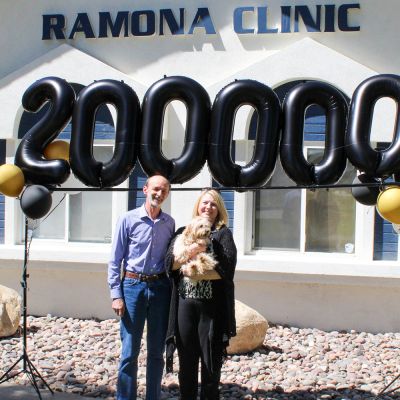 Photo of Dr. Popa with a client and their dog in front of the Romana Clinic.