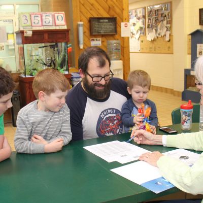 a woman meeting with a man and his three sons