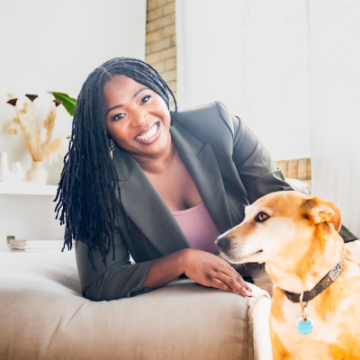 a woman leaning on a couch with a dog