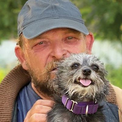 a man holding up his small dog