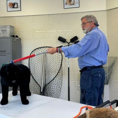 a man demonstrates how to use a control pole on a toy dog
