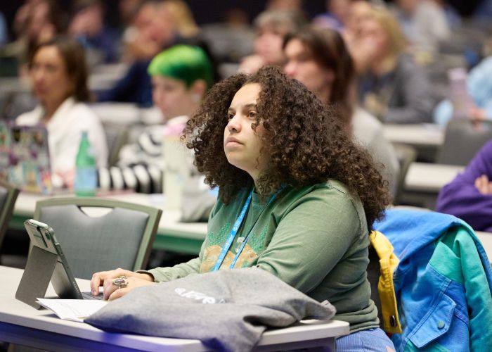 Attendee in workshop typing on laptop