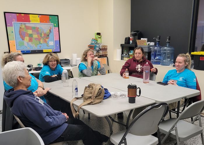 A group of volunteers sitting at a table in the care and rehab center.