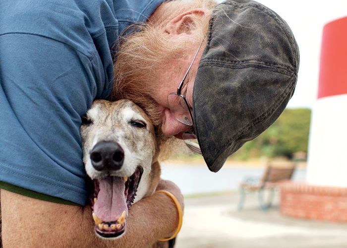 a man kissing an elderly dog