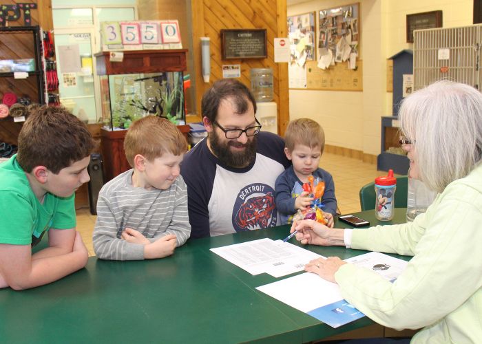 a woman meeting with a man and his three sons
