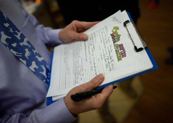 close up of a person filling out a shelter adoption form