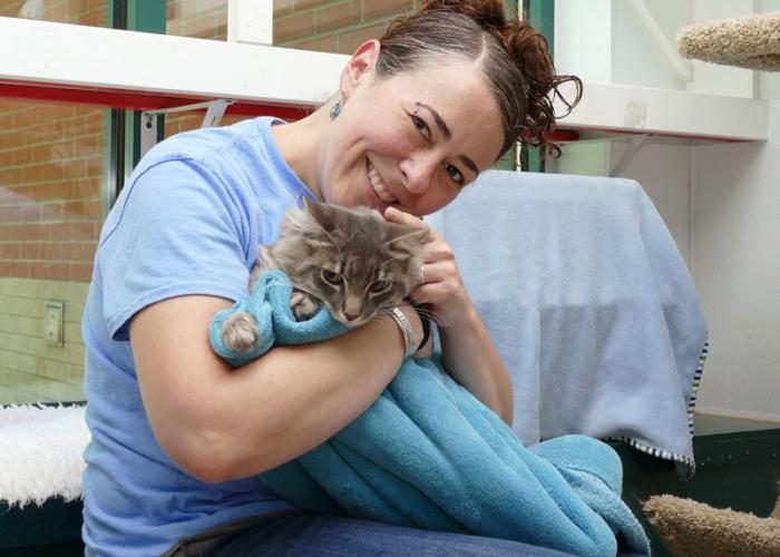 a woman cuddles a cat