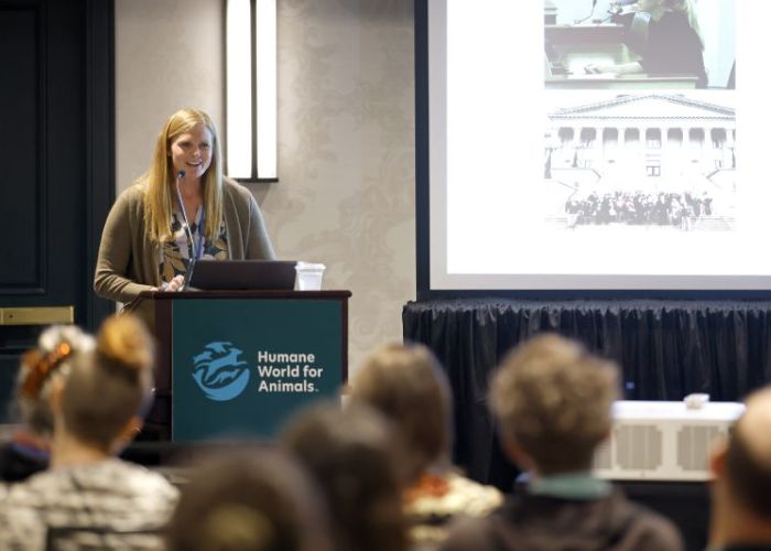 A speaker stands at the podium at Taking Action for Animals 2025