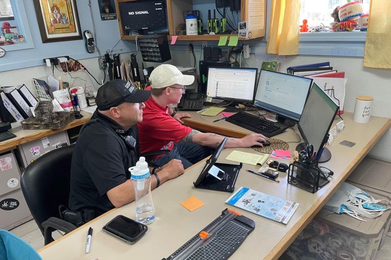 Two men working at a computer.