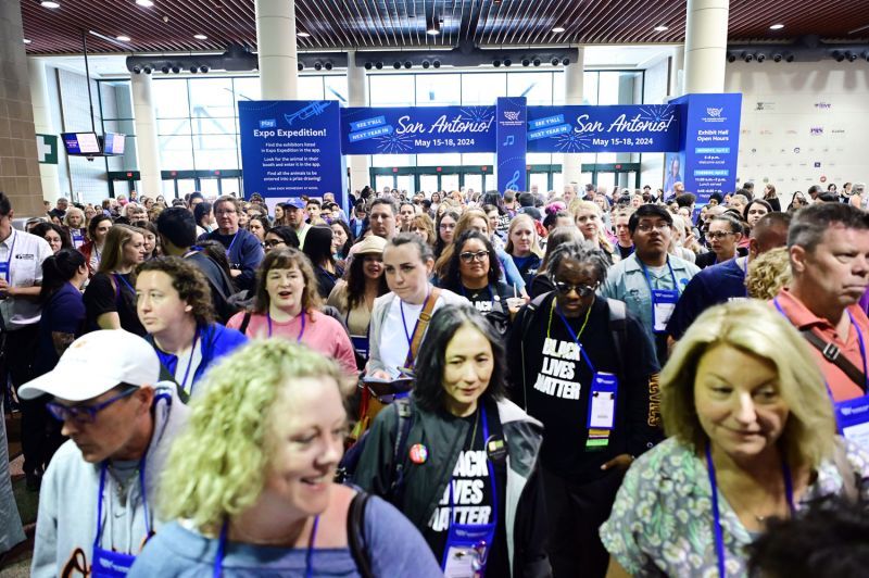 a large group of attendees enter the exhibit hall