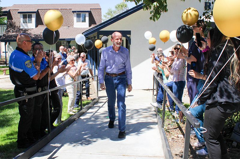 Dr. Popa walking through a crowd of applauding fans and colleagues. 